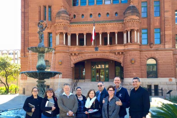 A group of people standing in front of a large building.