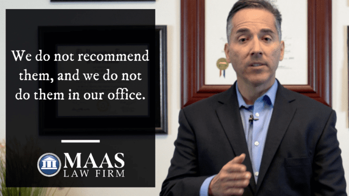 A man in a suit standing in front of a sign that says we do not recommend them and we do not recommend them in our office.
