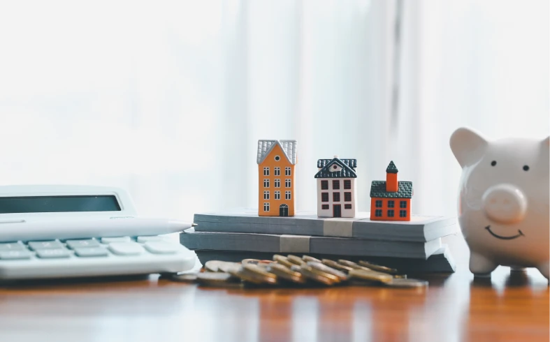 Calculator, piggy bank, and tiny house models
