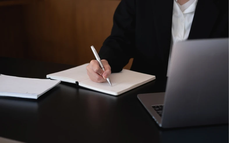Person writing notes at a desk