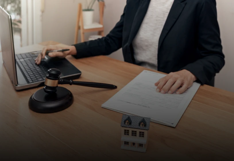 Office desk with gavel and house model