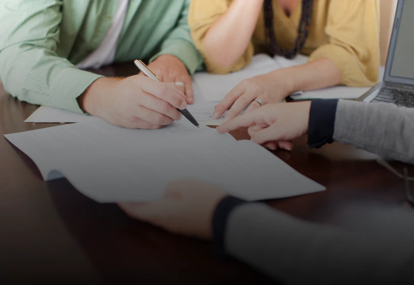 Group discussing paperwork with a laptop